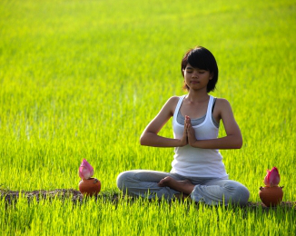 žena medituje v trávě