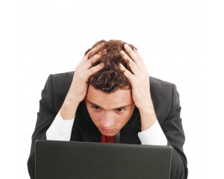 zoufalý muž hledí do PC a drží se za hlavu